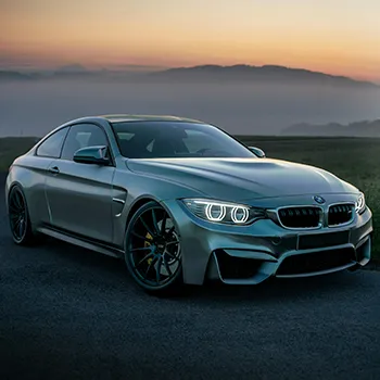 BMW M4 coupe parked on a scenic road, showcasing sleek design and performance features, relevant to expert BMW iDrive repair services in Castle Rock, CO at Titan Auto Tech.