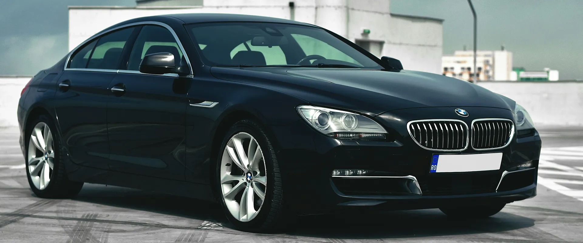 Black BMW 6 Series Gran Coupe parked on a rooftop, showcasing sleek design and modern features, relevant to BMW iDrive repair services in Castle Rock, CO.