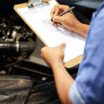 Technician reviewing maintenance checklist for BMW factory maintenance service at Titan Auto Tech in Castle Rock, CO.